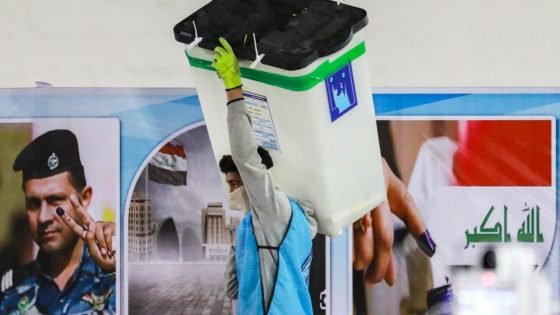 A worker of Iraq's Independent High Electoral Commission (IHEC) carries a sealed ballot box as others perform a manual count of votes to match the electronic count at one of the commission's headquarters in the Karkh district of Baghdad on December 23, 2023, days after the first provincial council vote held in a decade. Iraqis on December 18 voted in the local elections which were expected to strengthen the dominance of pro-Iranian Shiite Muslim groups. The vote comes at a time of widespread political apathy and disillusionment in the oil-rich country of 43 million that is still recovering from years of war and plagued by corruption. (Photo by MURTAJA LATEEF / AFP)