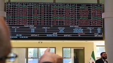 A man points at a trading board displaying the latest numbers at the Damascus Secutiries Exchange (DSE) as Syria's stock market opens the Ya'fur area near Damascus on June 2, 2025. (Photo by LOUAI BESHARA / AFP)