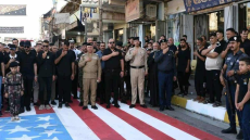 وزير الداخلية العراقي يعاقب ضباطاً شاركوا في فعالية تضمنت “دعس” العلم الأمريكي
