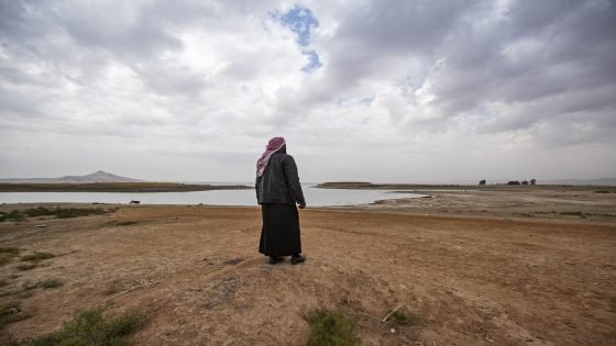 A Syrian man walks amidst drought and low water levels in the Euphrates River, in the western countryside of Tabqa in Syria's Raqqa governorate, on November 22, 2022. (Photo by Delil SOULEIMAN / AFP)