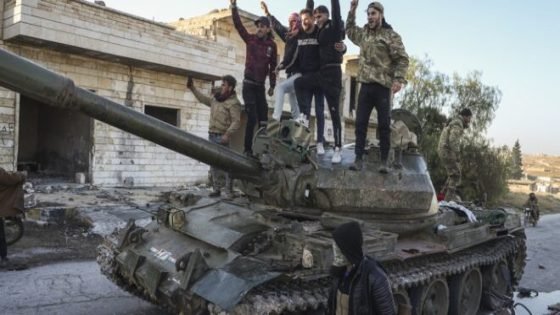Syrian opposition supporters stand atop a captured Syrian army tank in the town of Maarat al-Numan, southwest from Aleppo, Syria, Saturday Nov. 30, 2024. Thousands of Syrian insurgents have fanned out inside Syria's largest city Aleppo a day after storming it with little resistance from government troops.(AP Photo/Omar Albam)